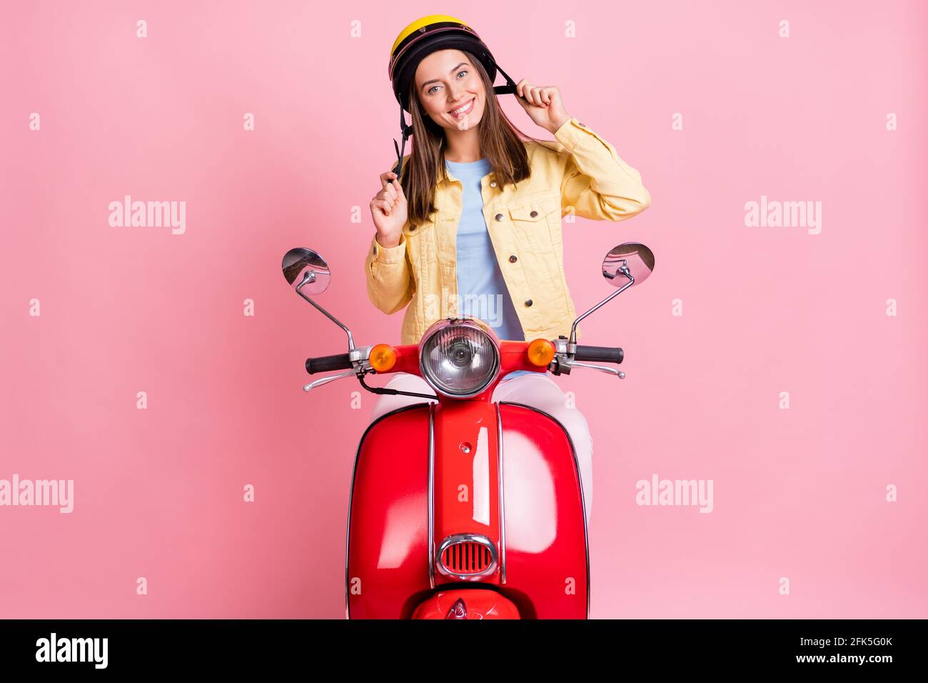 Foto de joven feliz positiva sonriente niña mujer ropa femenina paseo en  casco amarillo motocicleta roja aislada sobre fondo de color rosa  Fotografía de stock - Alamy