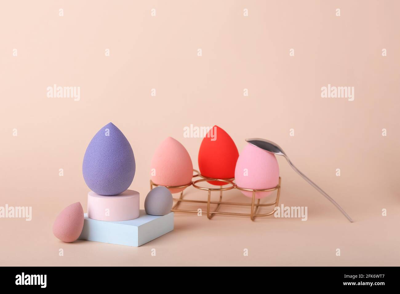 Composición creativa con porta huevos, esponjas de maquillaje y cuchara  sobre fondo de color Fotografía de stock - Alamy