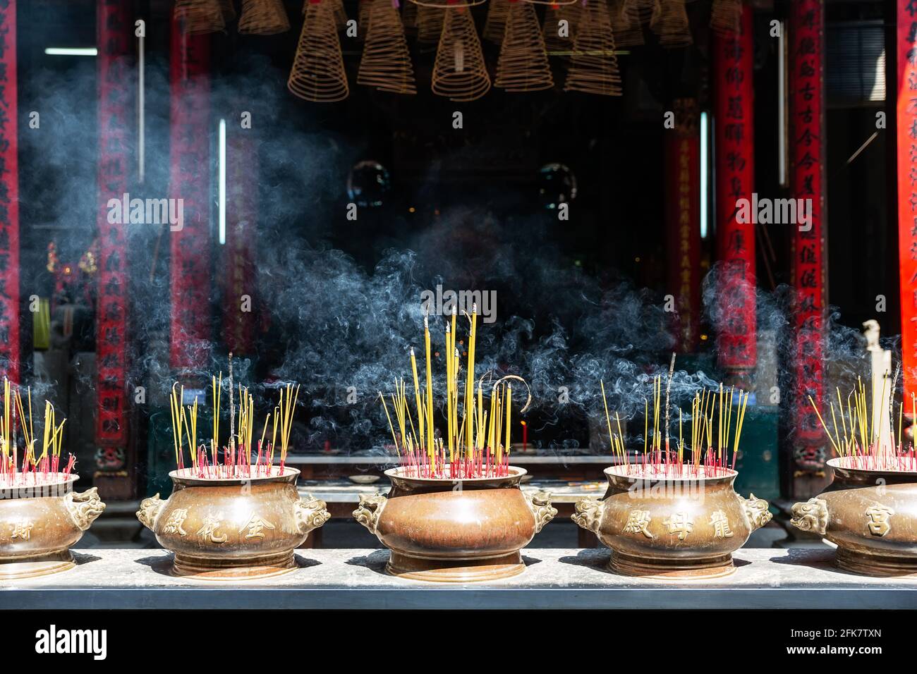 Quemando palos de incienso rojo en el templo chino. Incienso que se quema  en una olla, fondo borroso del templo chino Fotografía de stock - Alamy