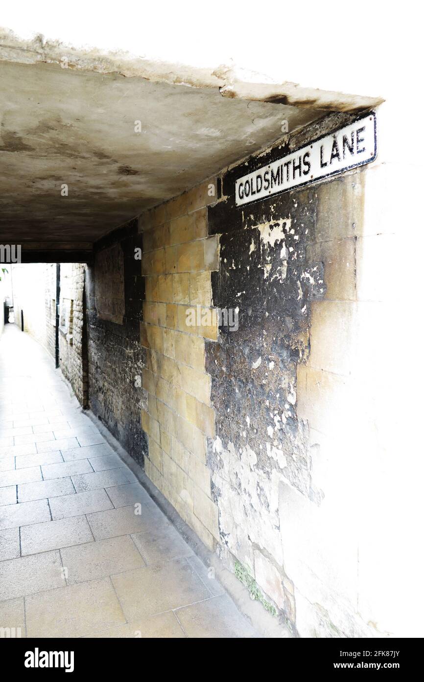 La entrada a Goldsmiths Lane, uno de los muchos callejones estrechos en Stamford, Lincolnshire. Una tienda de época o un cartel de pub se puede ver pintado en la pared. Foto de stock