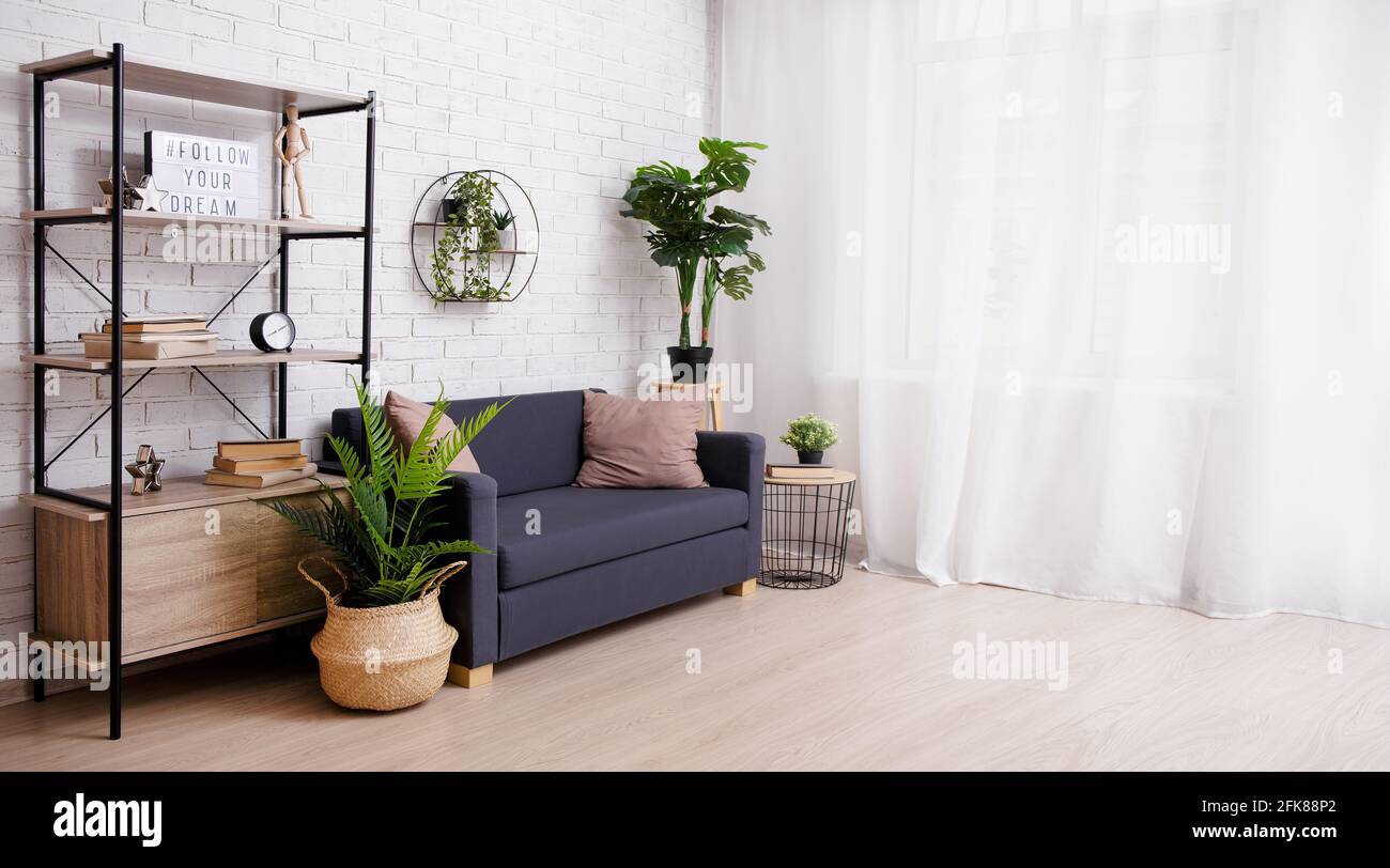Interior de una habitación con sofá, estante, plantas y ventana Fotografía  de stock - Alamy