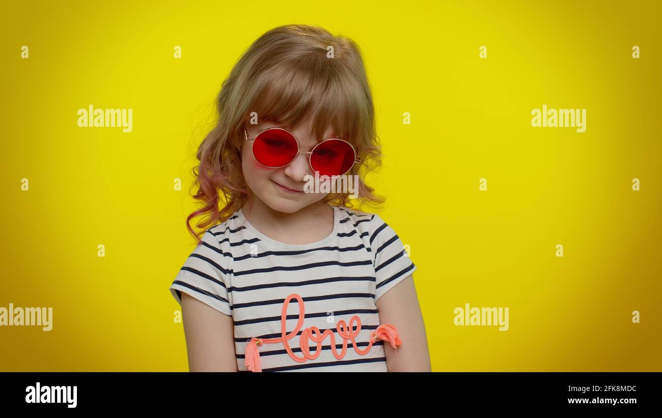 Divertido niño rubio divertido que lleva gafas de sol, mirando con una  sonrisa encantadora sobre fondo amarillo Fotografía de stock - Alamy