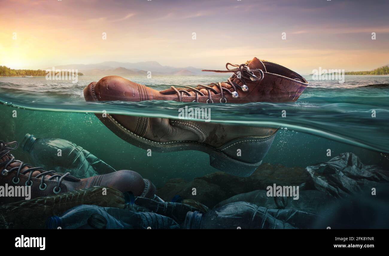 Contaminación plástica con botas de zapatos en la superficie del agua en el mar. Problema de medio ambiente Foto de stock