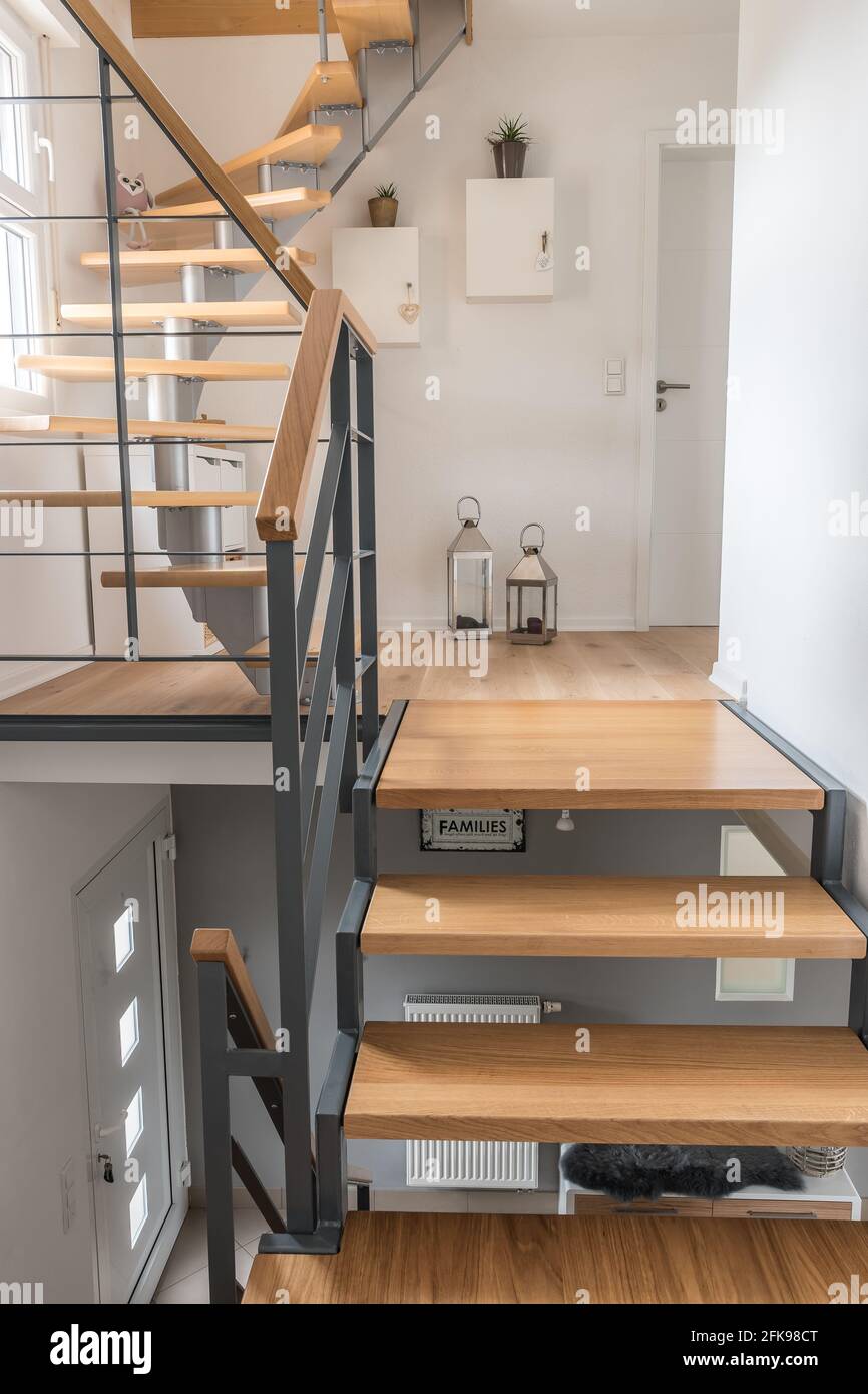 Escalera de una casa privada con escaleras modernas. Estructura de acero  con peldaños de madera, paredes blancas y grises, concepto de color  armonioso. Foto de stock vertical Fotografía de stock - Alamy
