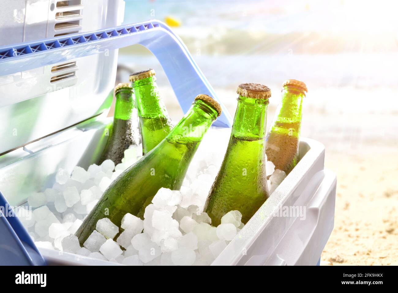 Botellas de cerveza frías sobre hielo en una nevera de camping en la playa  en un día caluroso con sol Fotografía de stock - Alamy