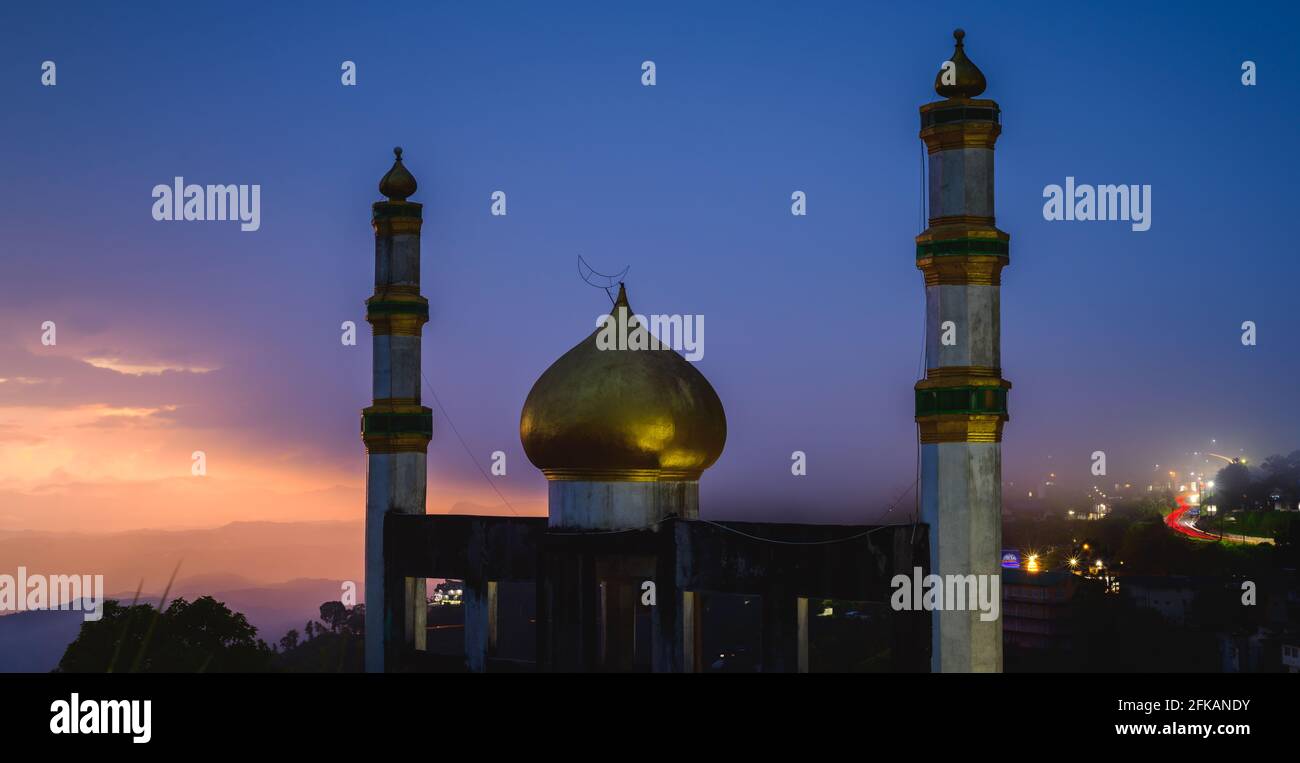 Mezquita Jummah Masjid en el paisaje nocturno Fotografía de larga exposición, la ciudad de Halutale está en el fondo, Foto de stock