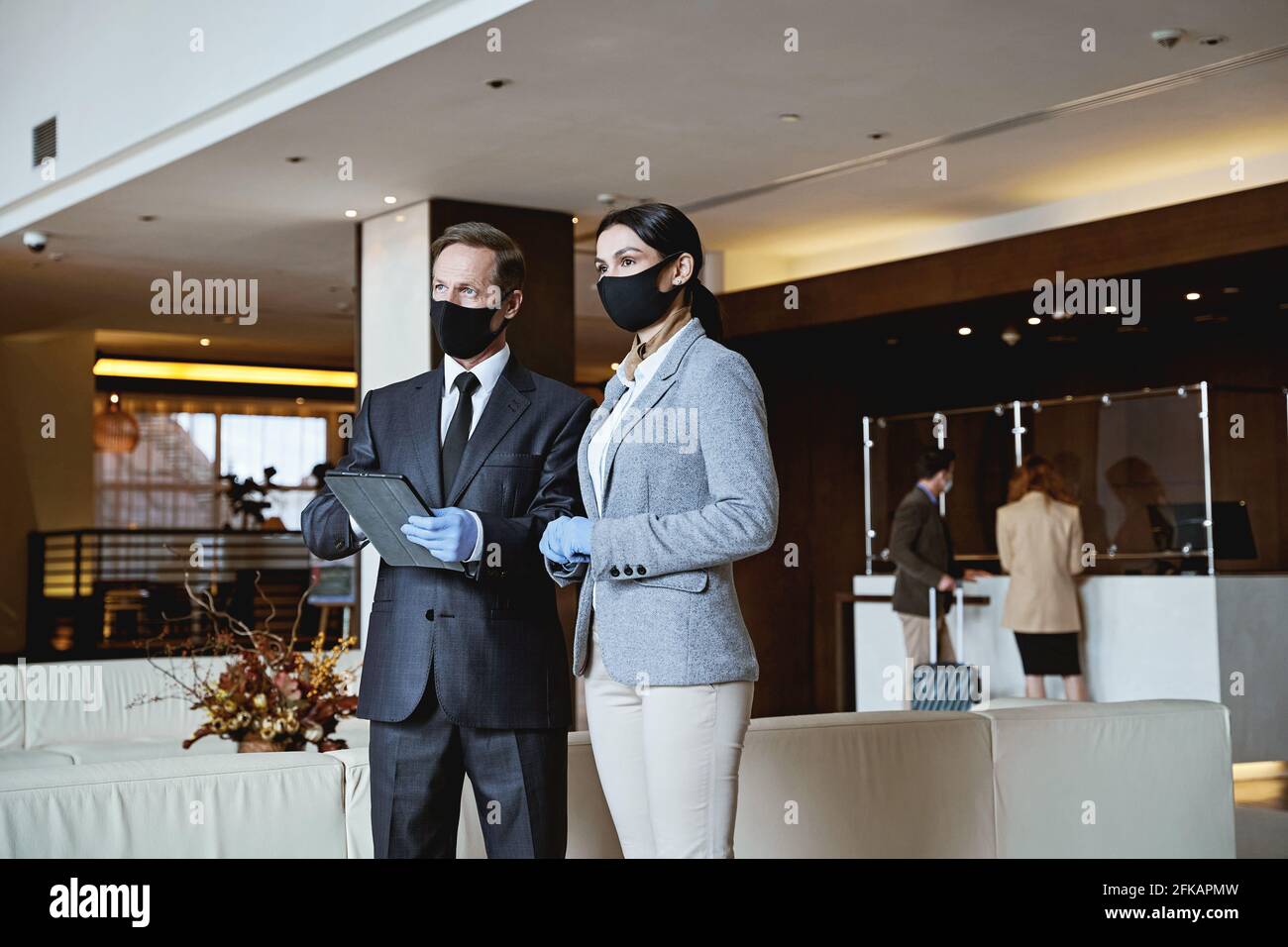 El empleado del hotel trabaja en equipo mientras los huéspedes llegan