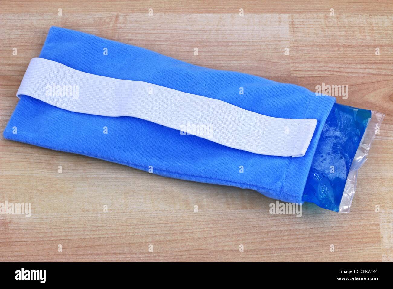 Un paquete frío y caliente de gel suave reutilizable azul para aliviar el dolor dentro de una bolsa de tela Foto de stock