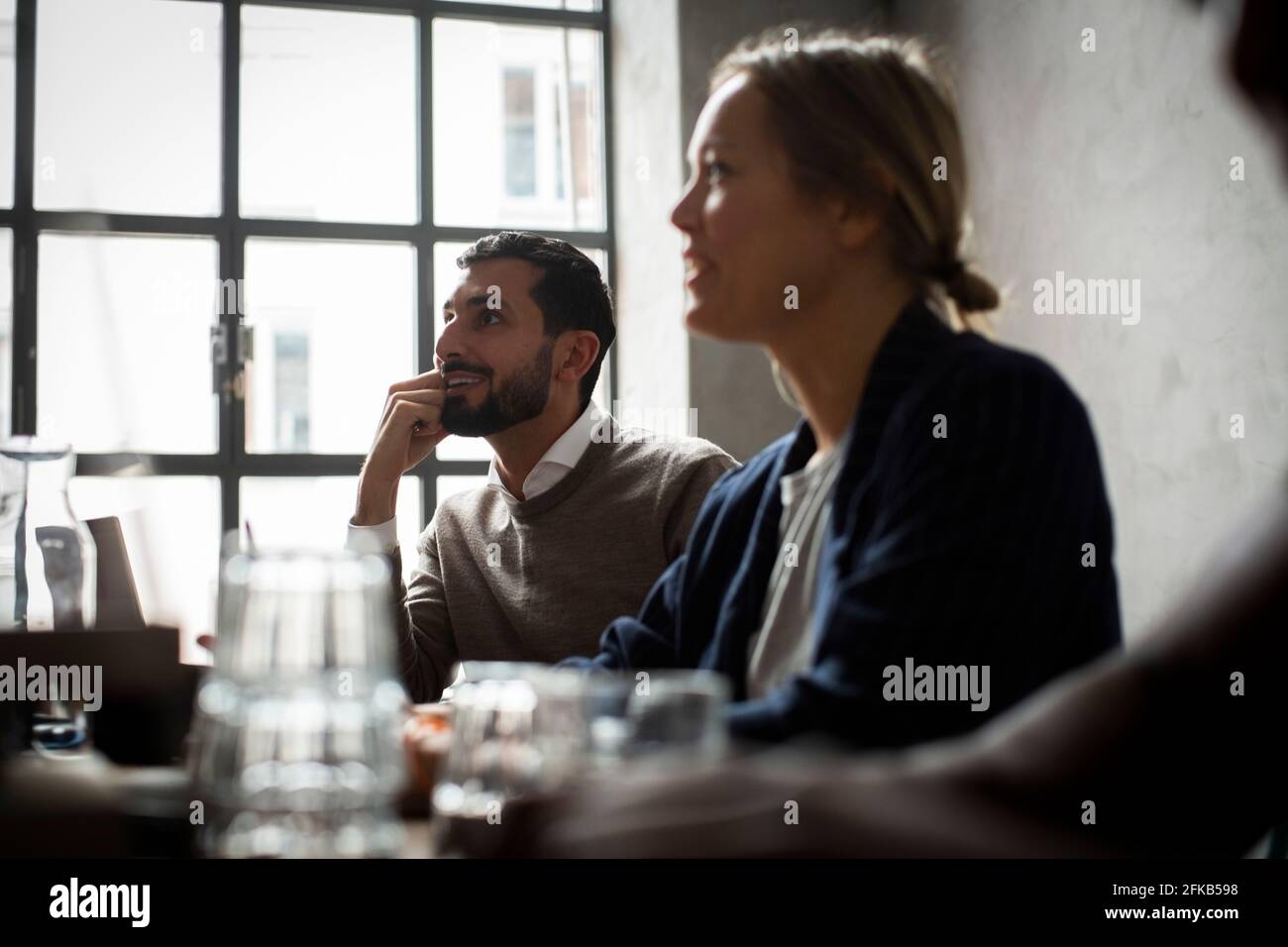 Mujer de negocios con colega masculino en discusión durante la reunión en la oficina Foto de stock