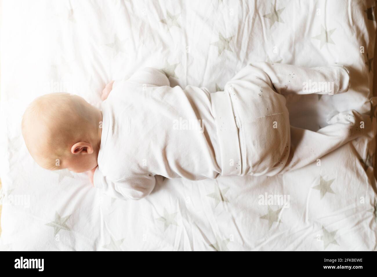 justo encima de la vista de un bebé de un mes en manta tratando de levantar la cabeza Foto de stock