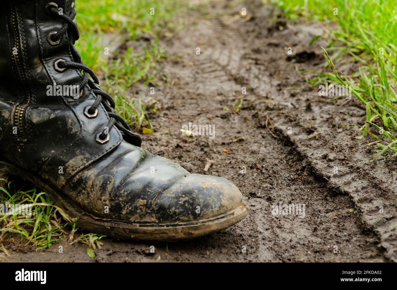 Los pies de un hombre en botas en la fangosa carretera de campo. Tierra  sucia. Botas sucias del ejército caminando por la carretera lluviosa.  Resorte. Otoño Fotografía de stock - Alamy