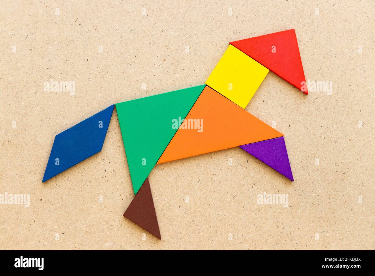 Rompecabezas de color tangram en forma de caballo o mustang sobre fondo de  madera Fotografía de stock - Alamy