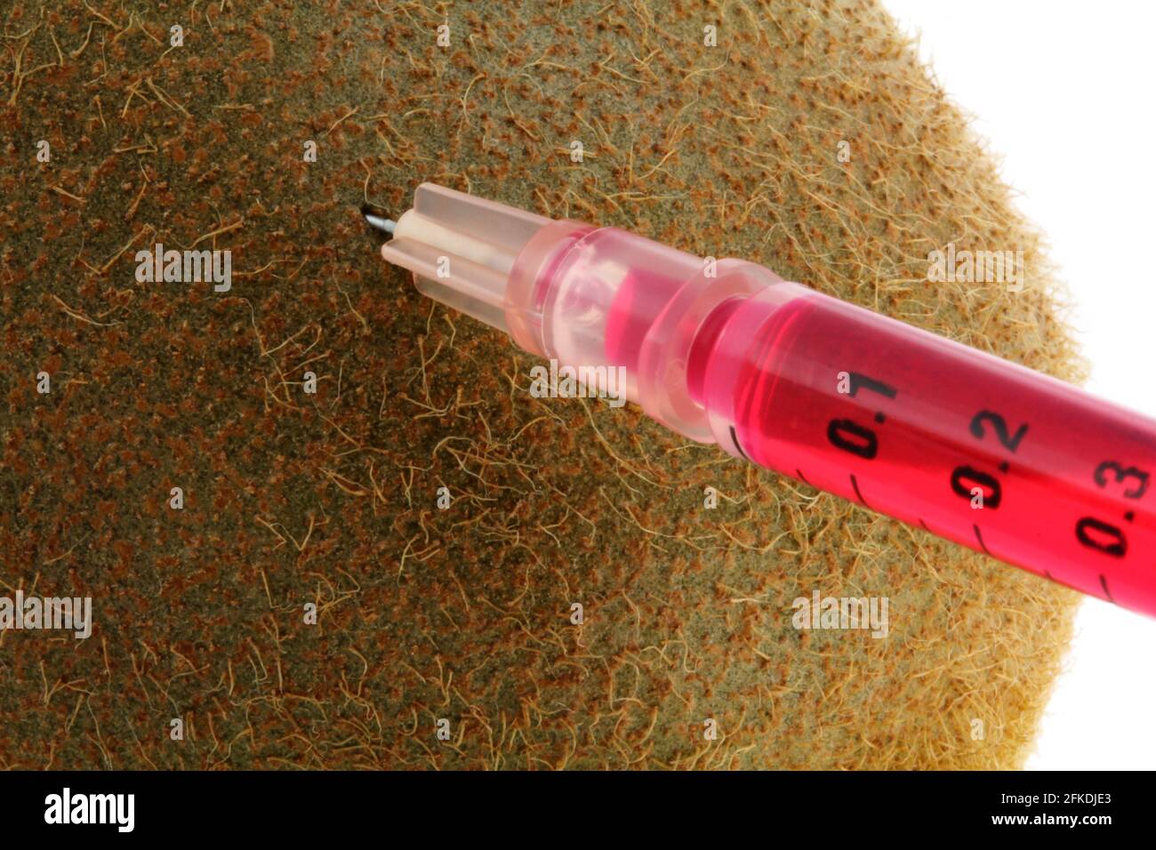 Foto conceptual de la modificación genética - Líquido rojo inyectándose en un kiwi Foto de stock