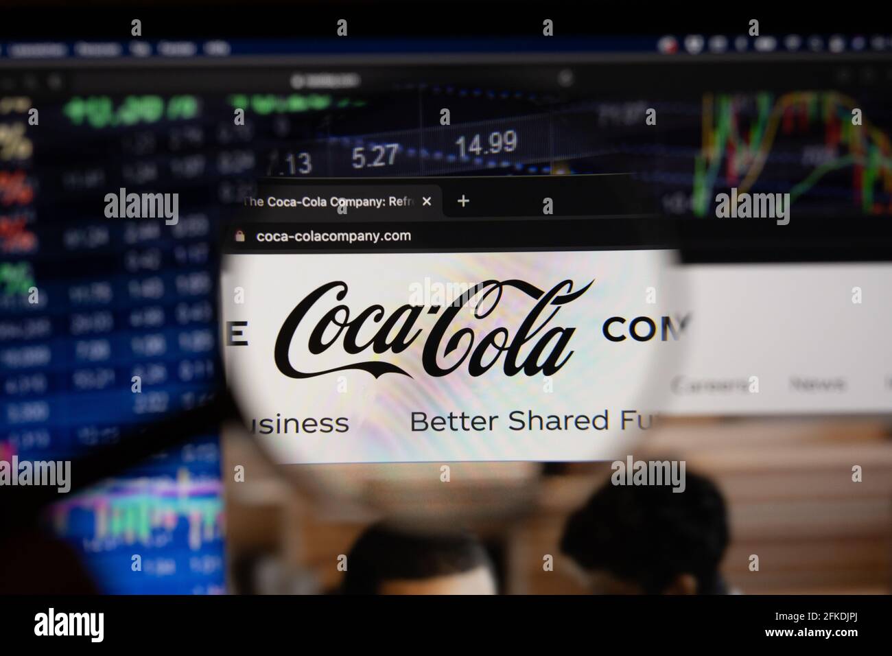 El logotipo de la empresa Coca Cola en un sitio web con los desarrollos  borrosos del mercado de valores en el fondo, visto en una pantalla de  ordenador a través de una