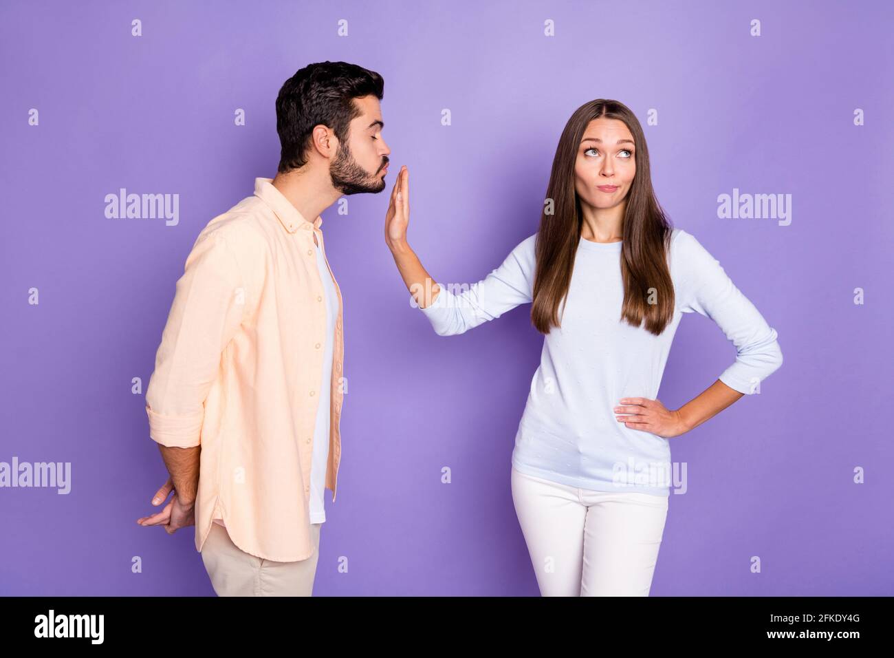 Foto de morena gente hombre enviar aire beso mujer rechazar la cintura de  la mano ignora el color de fondo morado aislado Fotografía de stock - Alamy