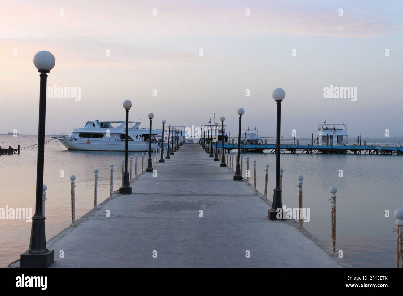 Muelle y barcos en el mar. El cielo anterior al amanecer. Un minuto antes del amanecer. Mar Rojo, Safaga, Egipto. Foto de stock