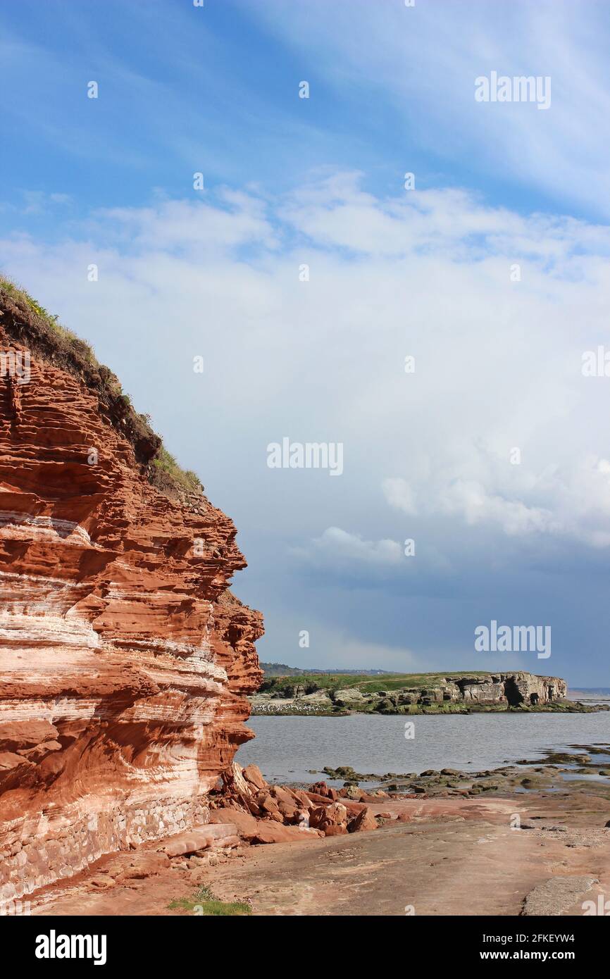 Bunter Sandstone Cliff en la isla de Hilbre, mirando hacia el ojo medio en High Tide, el Wirral, Merseyside, Reino Unido Foto de stock
