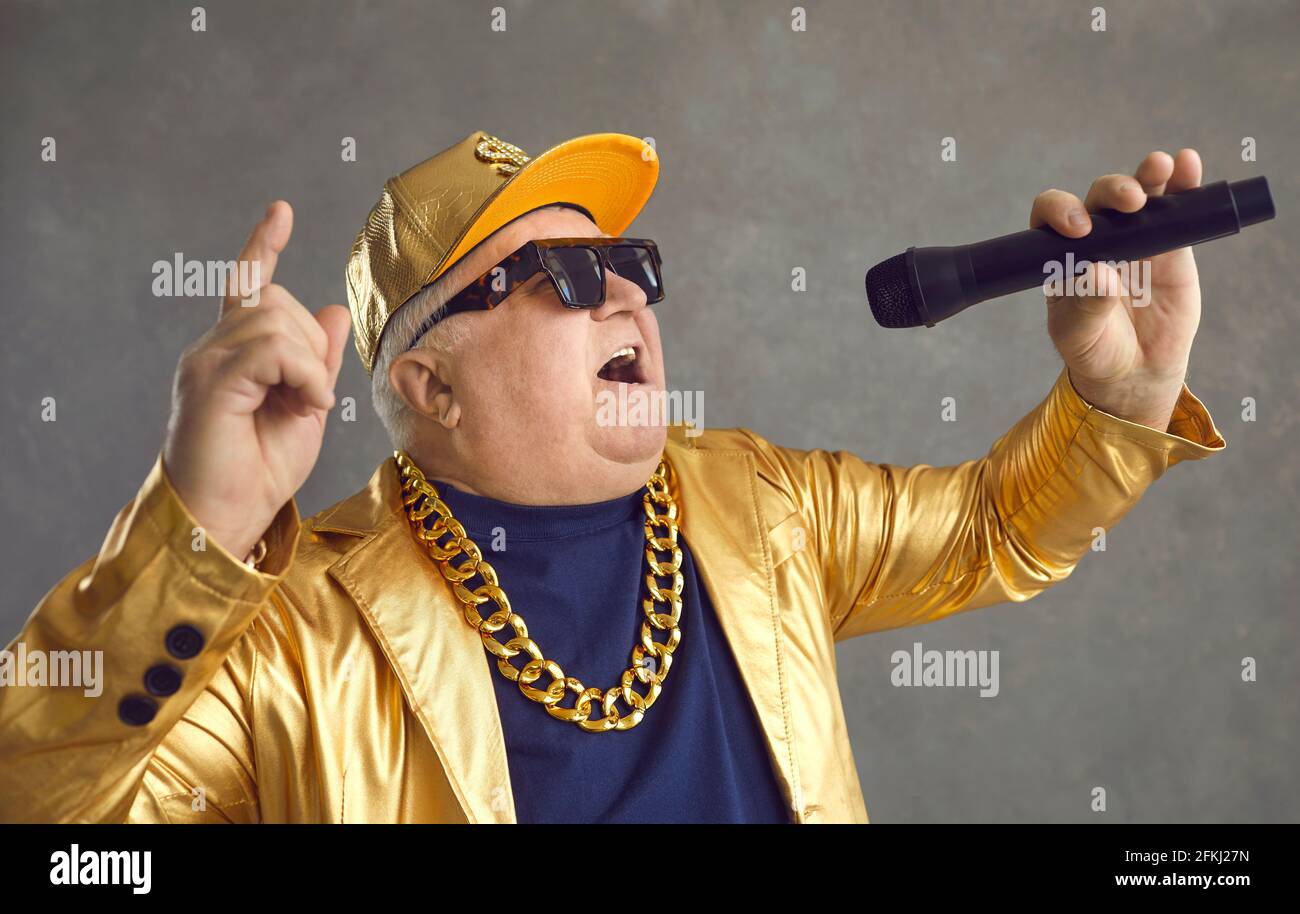 Retrato de estudio del hombre mayor chubby feliz con micrófono rapping y divertirse Foto de stock