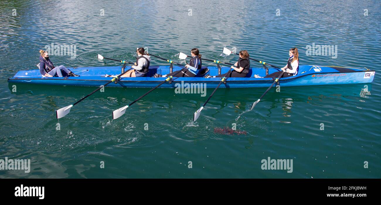 Cuatro niñas que se escrúllen aprendiendo a remar o a escrull. Foto de stock