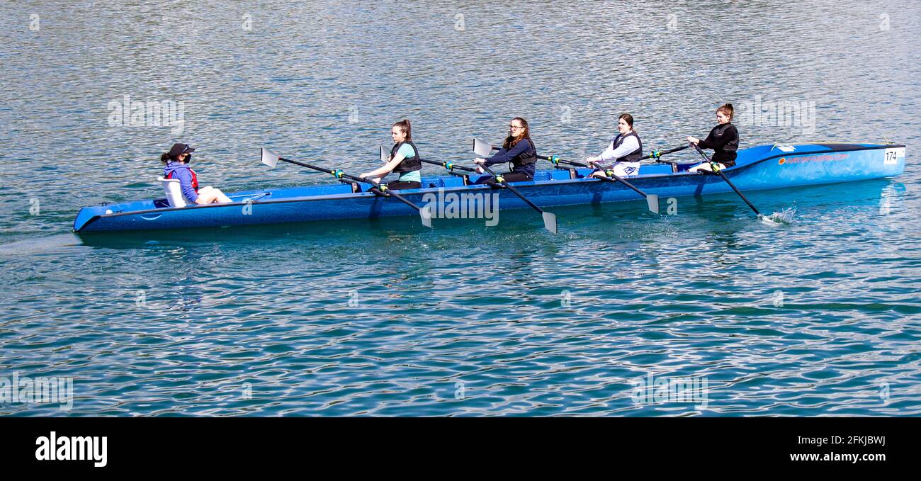 Cuatro niñas que se escrúllen aprendiendo a remar o a escrull. Foto de stock