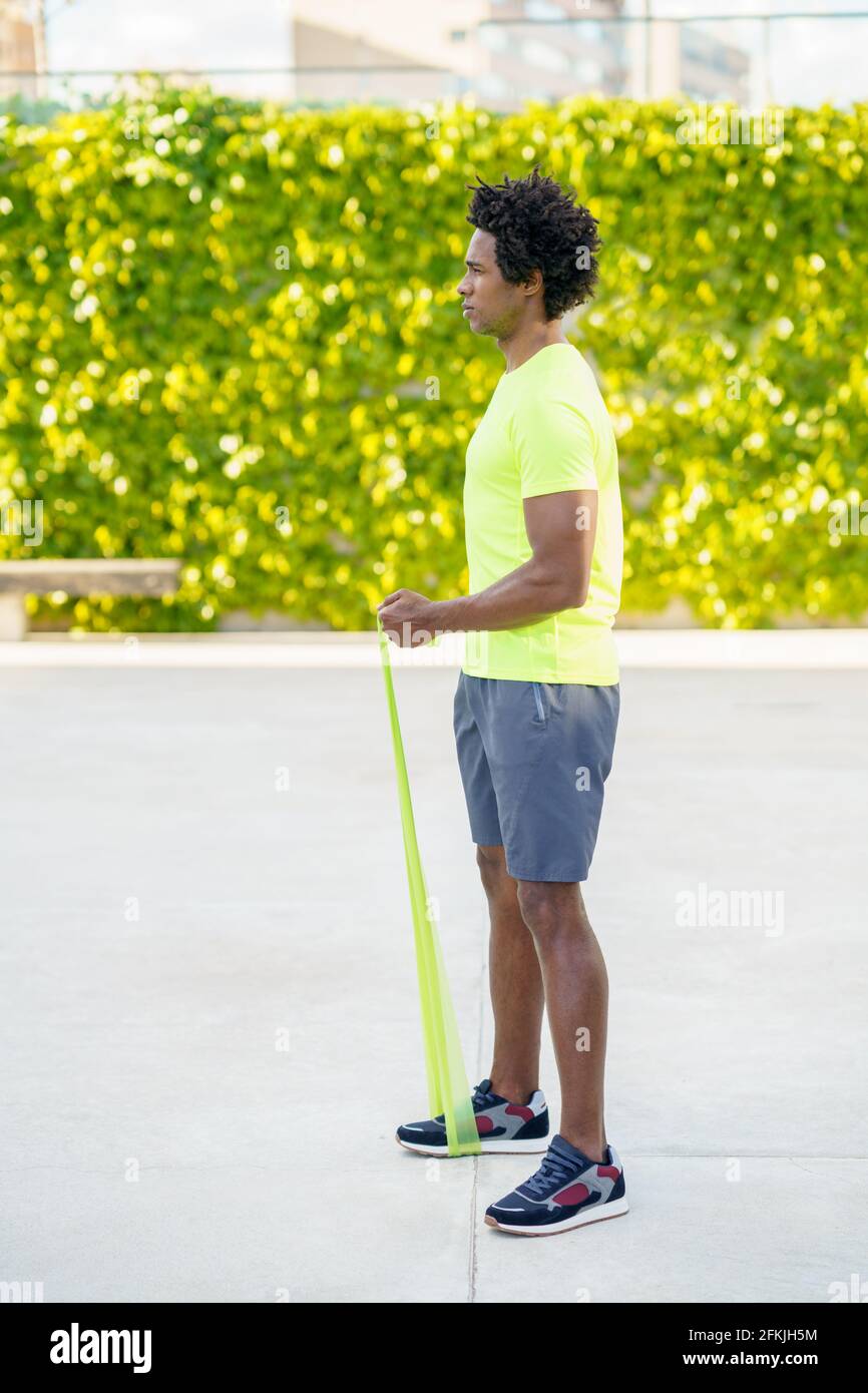 Hombre negro haciendo ejercicio con banda elástica al aire libre Foto de stock