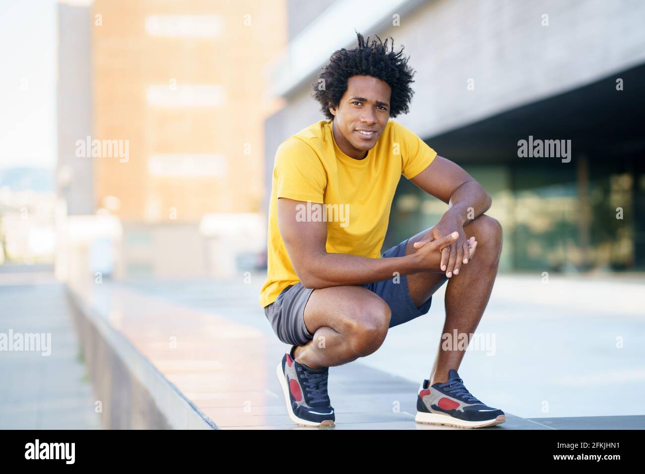 Hombre negro con pelo afro tomando un descanso después del entrenamiento. Foto de stock