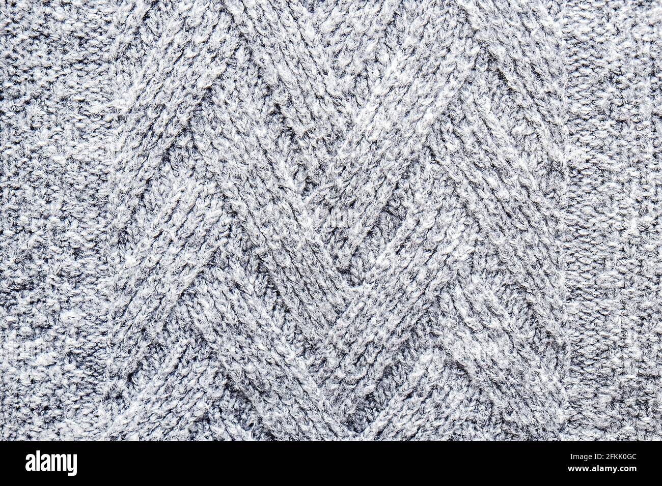 Foto corta de primer plano de tejido de lana sin costuras de otoño / invierno cálido jersey, textura de fibra claramente visible de elegante punto de cintura baja Foto de stock