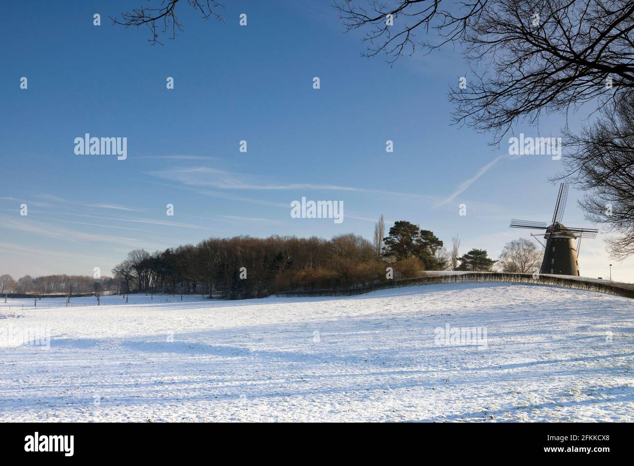 Molino de viento en un paisaje nevado cerca de Ubachsberg Foto de stock