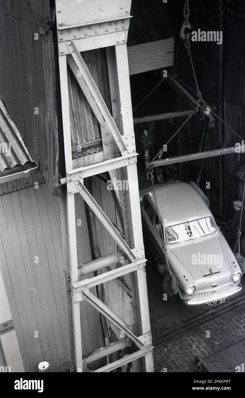 1950s, histórico, en el muelle, un Austin Cambridge A40 coche que se deja caer a las tierras secas desde el casco de un barco, Irlanda. Foto de stock