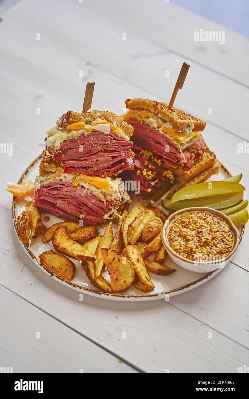 Sabrosos sándwiches de reuben a la parrilla de gran lujo con carne de pastrami y queso cheddar Foto de stock