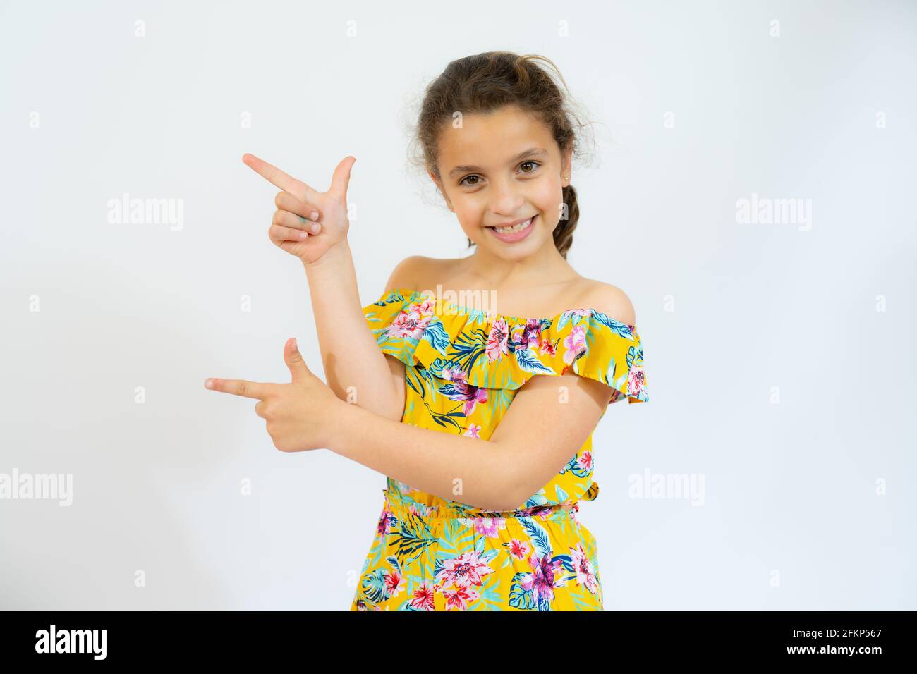 Niña hermosa usando ropa informal sonriendo y mirando la cámara apuntando  con dos manos y dedos al lado Fotografía de stock - Alamy