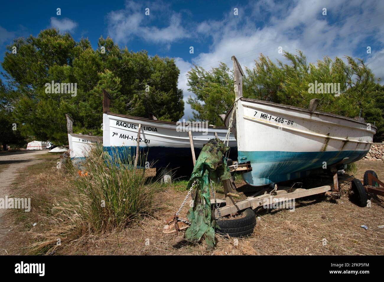 tres barcos de pesca tradicionales almacenados en el interior para el invierno en Es Grau menorca Foto de stock