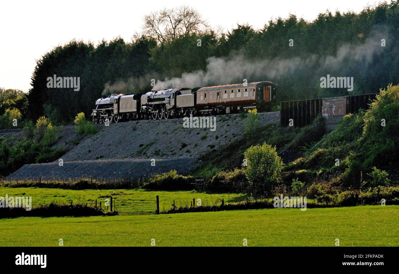 Por la noche, el sol Negro Five No 45305 y el BR Standard No 70013 Oliver Cromwell se dirigen al oeste con un autobús de apoyo para recoger el ferrocarril Gran Bretaña 4. Foto de stock