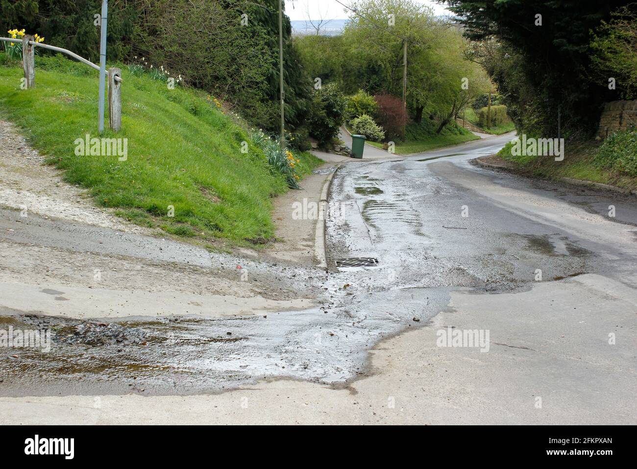 La primavera subterránea natural inunda en la carretera creando baches y. Fluye hacia abajo por la colina en Southend Garsington Oxford Foto de stock