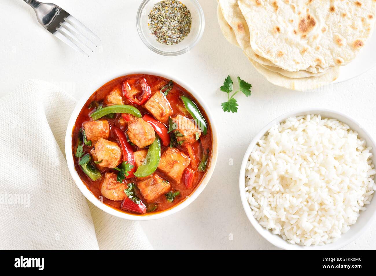 Curry de pollo rojo de estilo tailandés y arroz sobre fondo claro. Vista superior, diseño plano Foto de stock