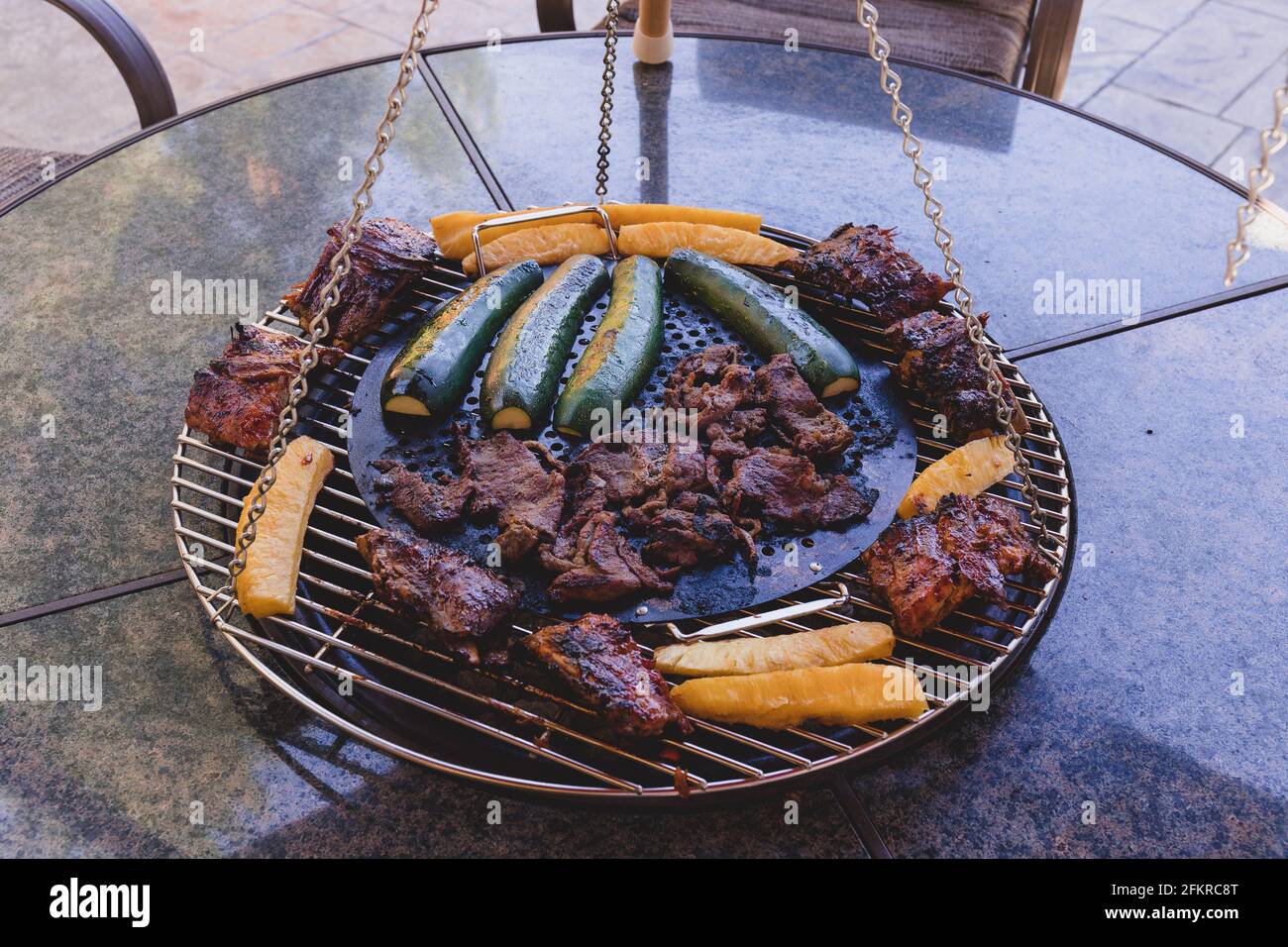 Parrilla de carne y verduras en el patio trasero Barbacoa Grill en el medio De la tabla Foto de stock