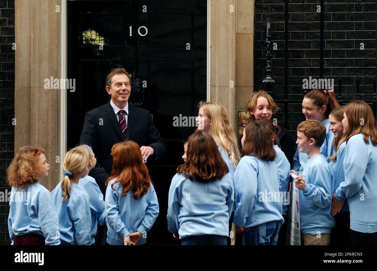 El primer Ministro Tony Blair saluda a los niños que representan a la granja infantil Carta de Bienestar de los animales con el mensaje que los comemos (Animales de granja).les debemos una feliz foto del life28 de noviembre de 2002 Andy Paraíso Foto de stock