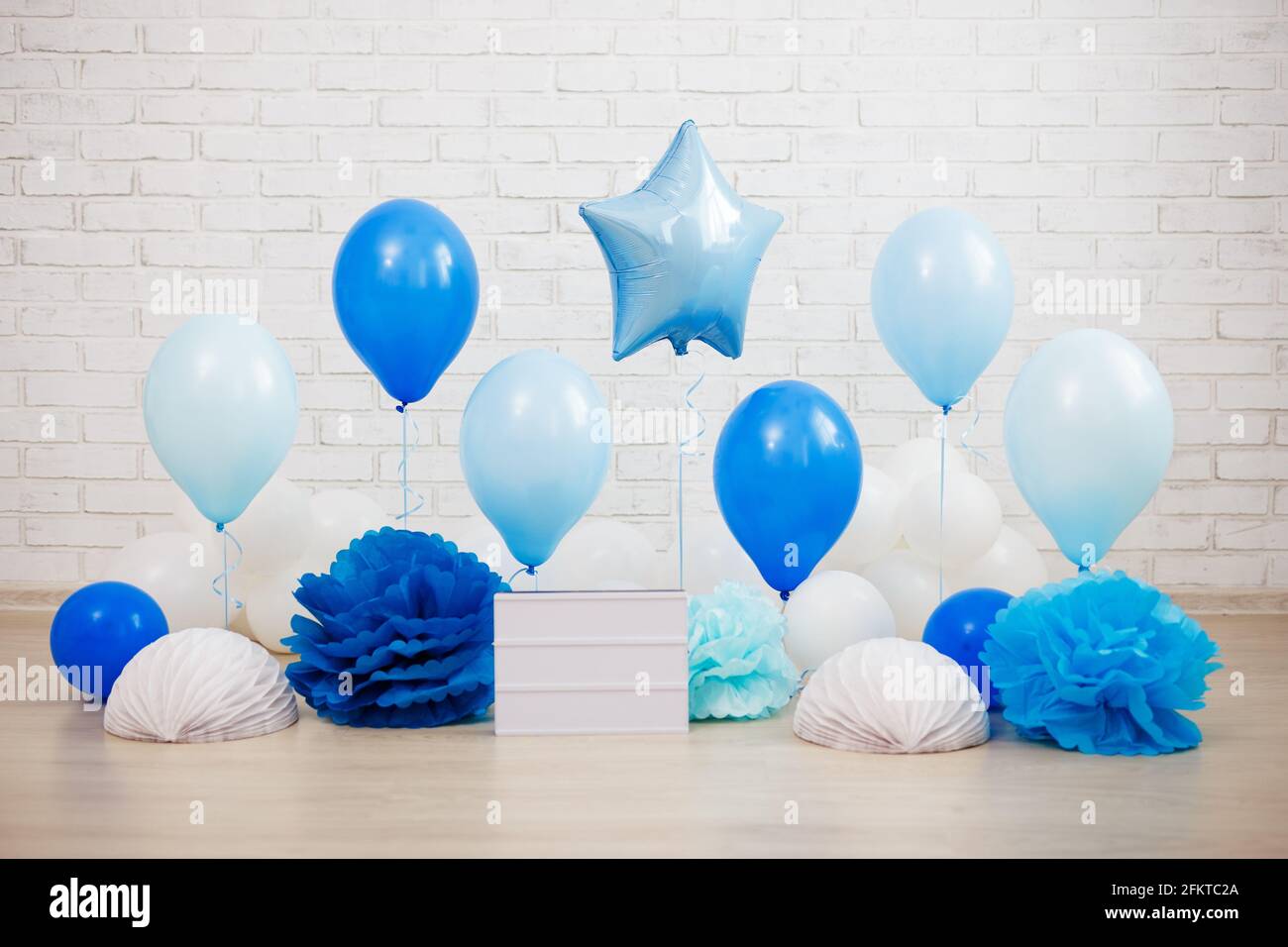 decoración de cumpleaños - globos de aire azul, bolas de papel y caja de  luz en blanco con espacio de copia sobre fondo de pared de ladrillo blanco  Fotografía de stock - Alamy