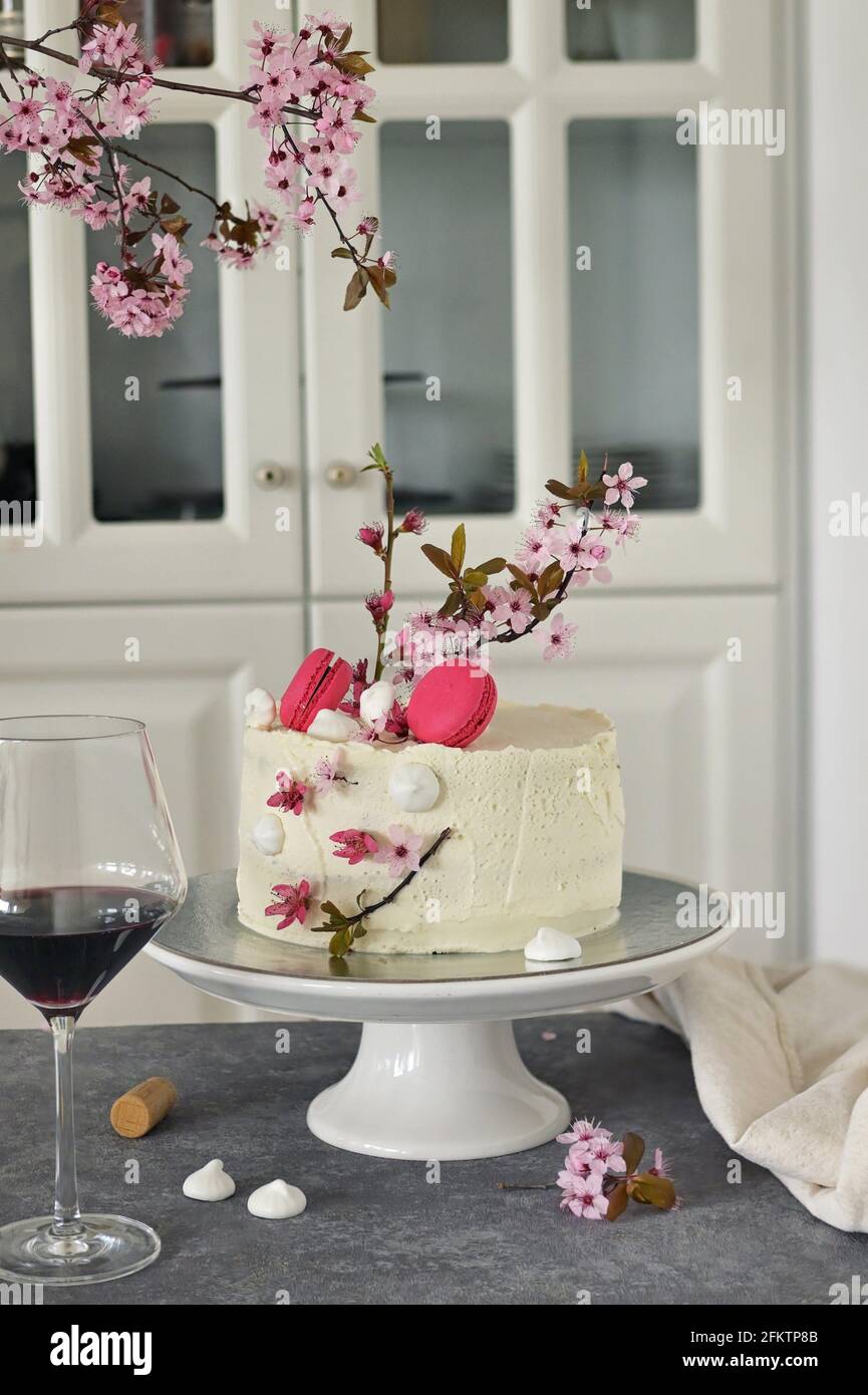 Pastel de aniversario de primavera decorado con flores y una copa de vino  Fotografía de stock - Alamy