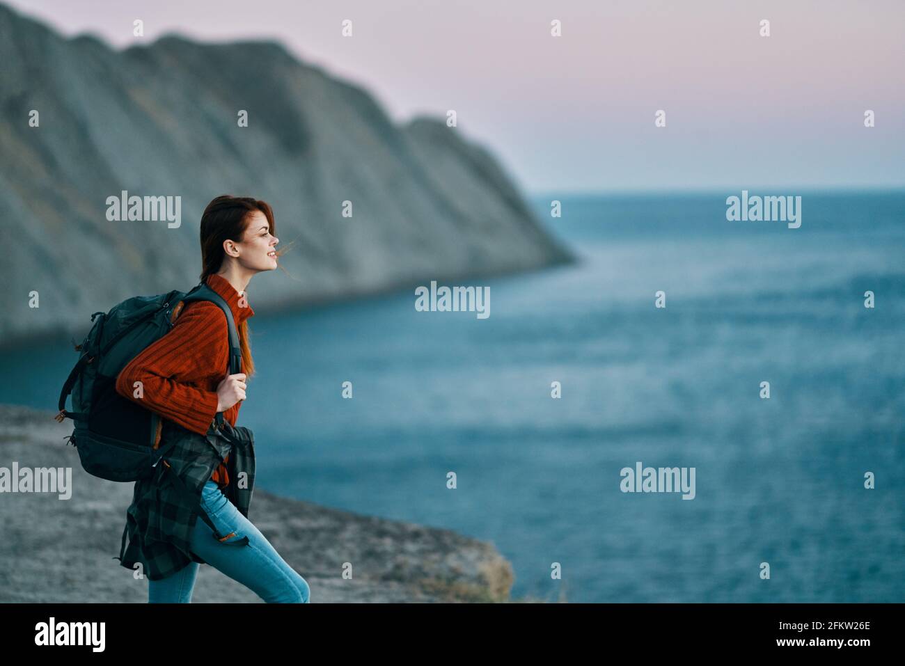 Viajar con una mochila en las montañas al aire libre mirando el modelo de  pantalones vaqueros rojo mar Fotografía de stock - Alamy