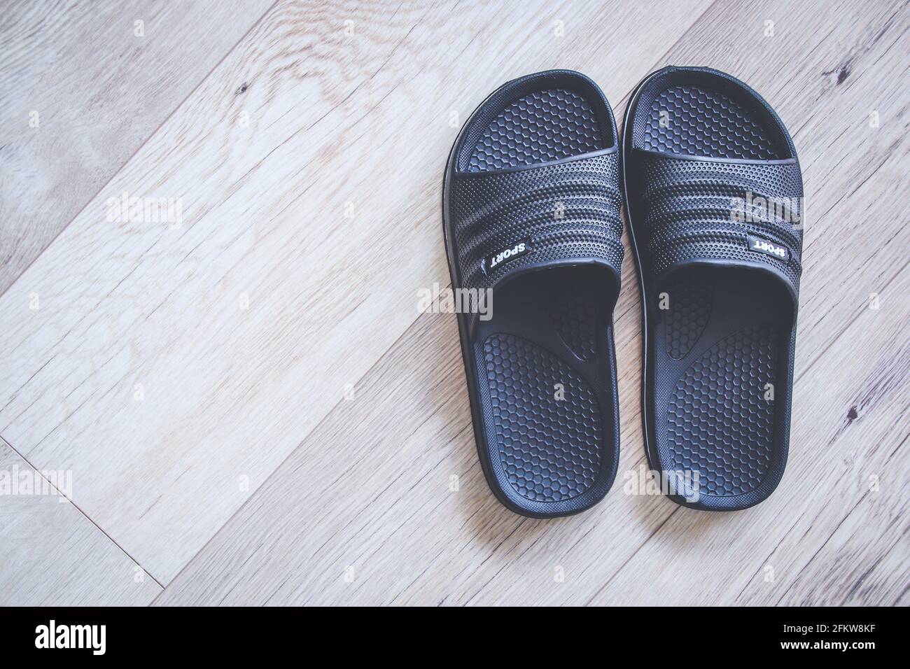 Dos chanclas negras para hombre sobre suelo de madera con espacio de copia  Fotografía de stock - Alamy