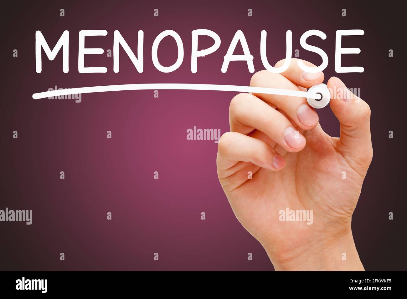 Escribir a mano la palabra Menopausia con marcador blanco sobre fondo rosa oscuro. Concepto sobre la Menopausia Transición a una nueva fase de la vida cuando el menstr Foto de stock