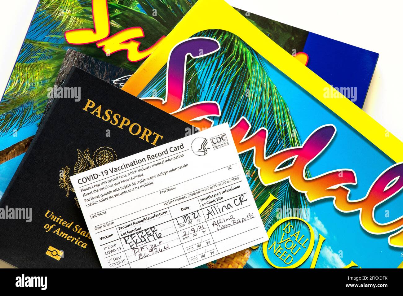 Minnesota; EE. UU. Tarjeta de registro de vacunación Covid-19 con pasaporte y folletos de viajes internacionales de Sandal. Foto de stock