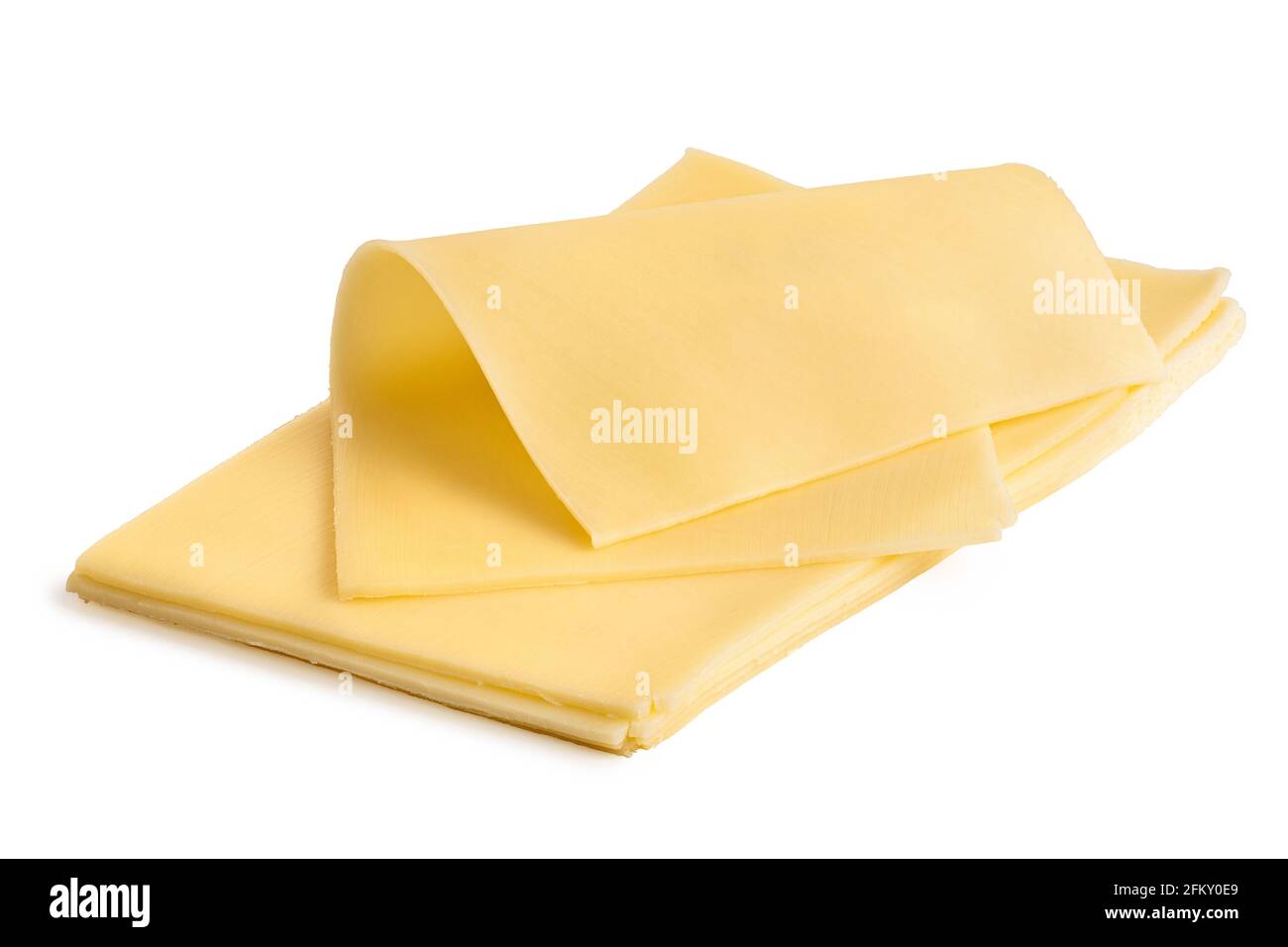 Rodaja delgada doblada de queso amarillo encima de una pila de rodajas de queso amarillo. Foto de stock