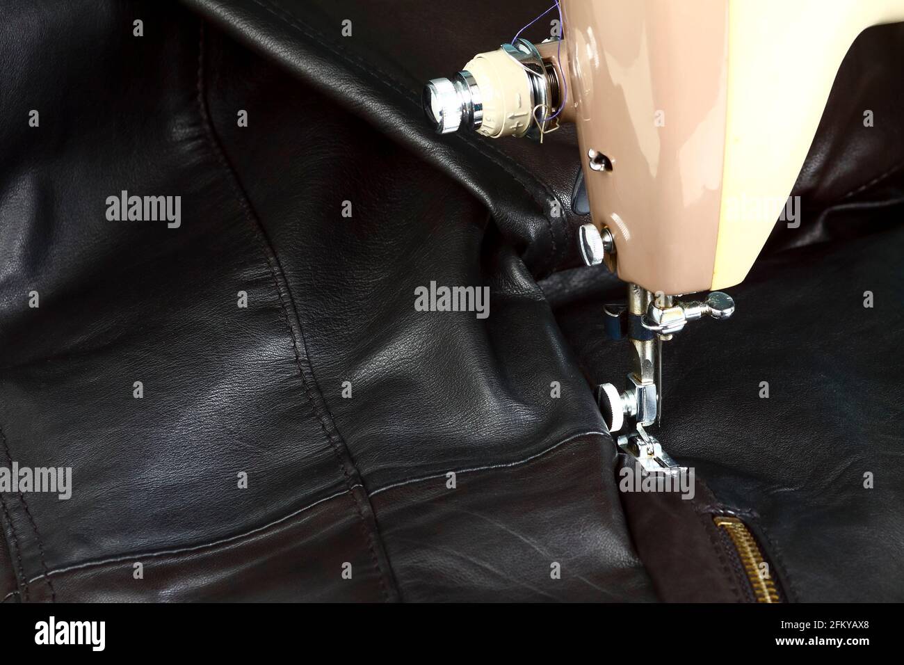 Primer plano de una máquina de coser de época y ropa de cuero en reparación  Fotografía de stock - Alamy