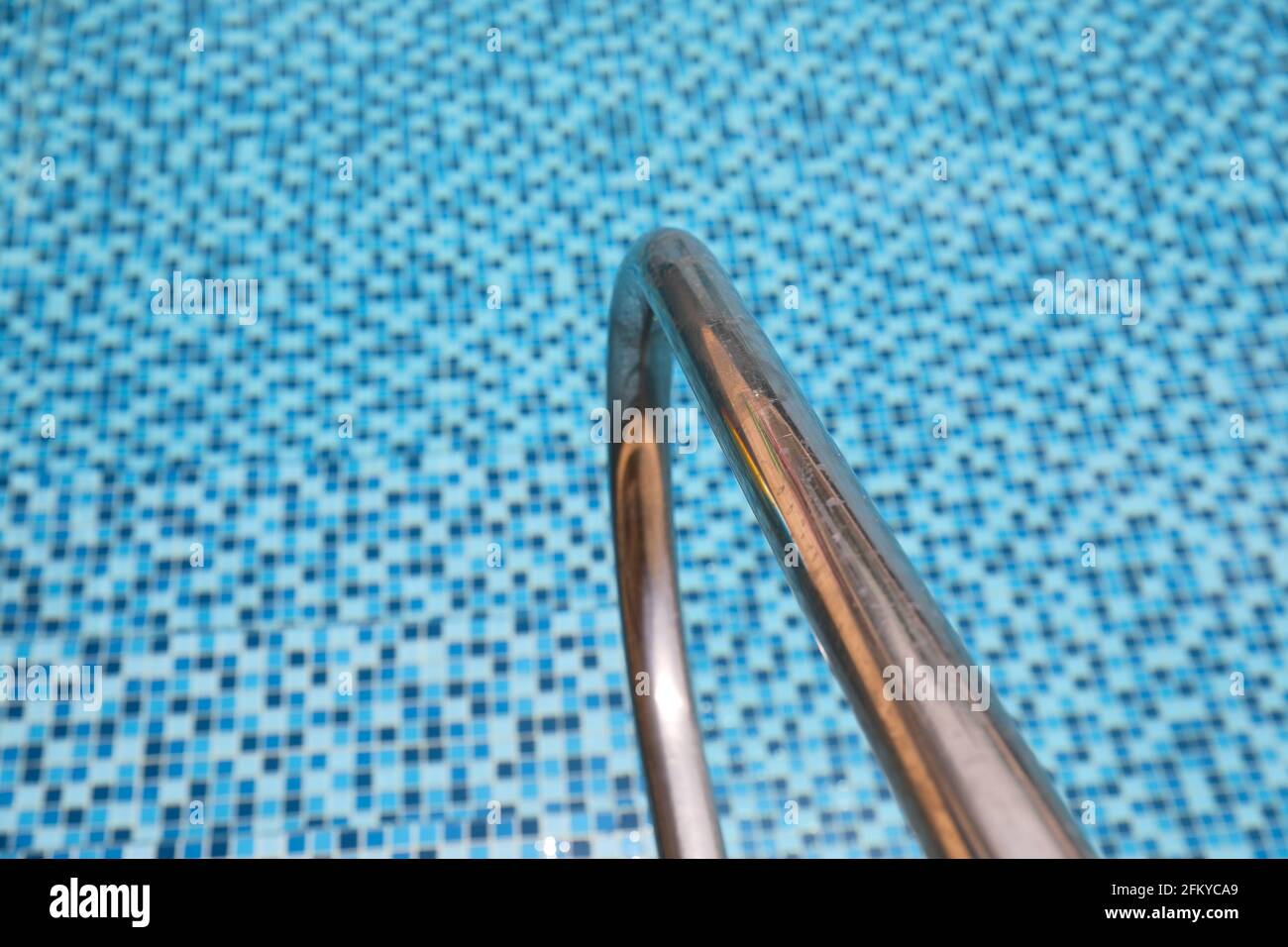 Barras de agarre escalera en una piscina azul. Foto de stock