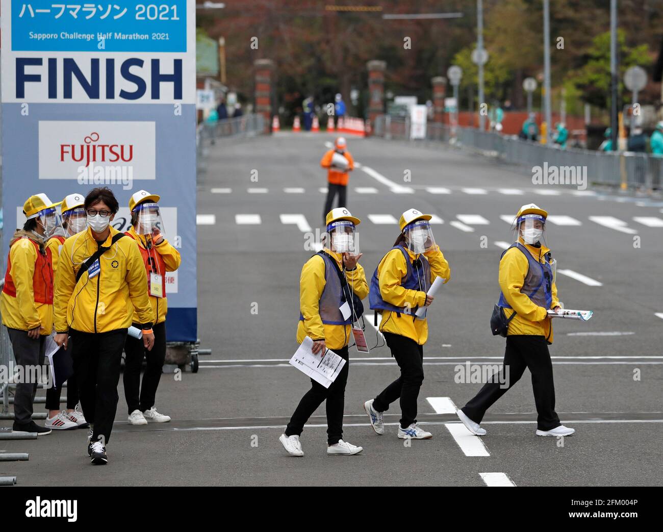 Los oficiales que llevan máscaras y escudos protectores se ven en el punto  final de la media maratón del Festival de Maratón Hokkaido-Sapporo 2021, un  evento de prueba para la carrera de
