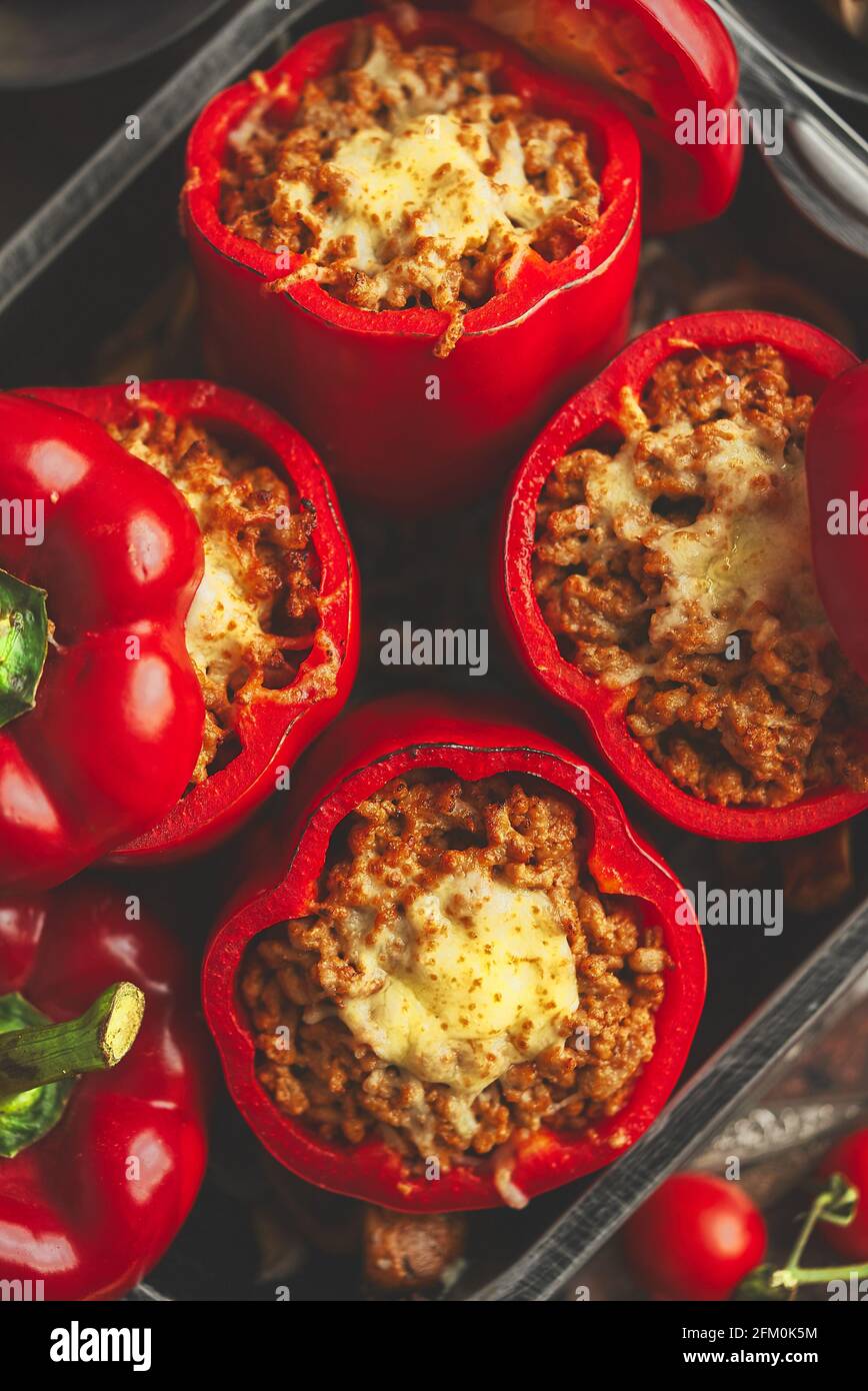 Pimientos rojos rellenos de carne de res y queso mozarella con hierbas y ajo Foto de stock