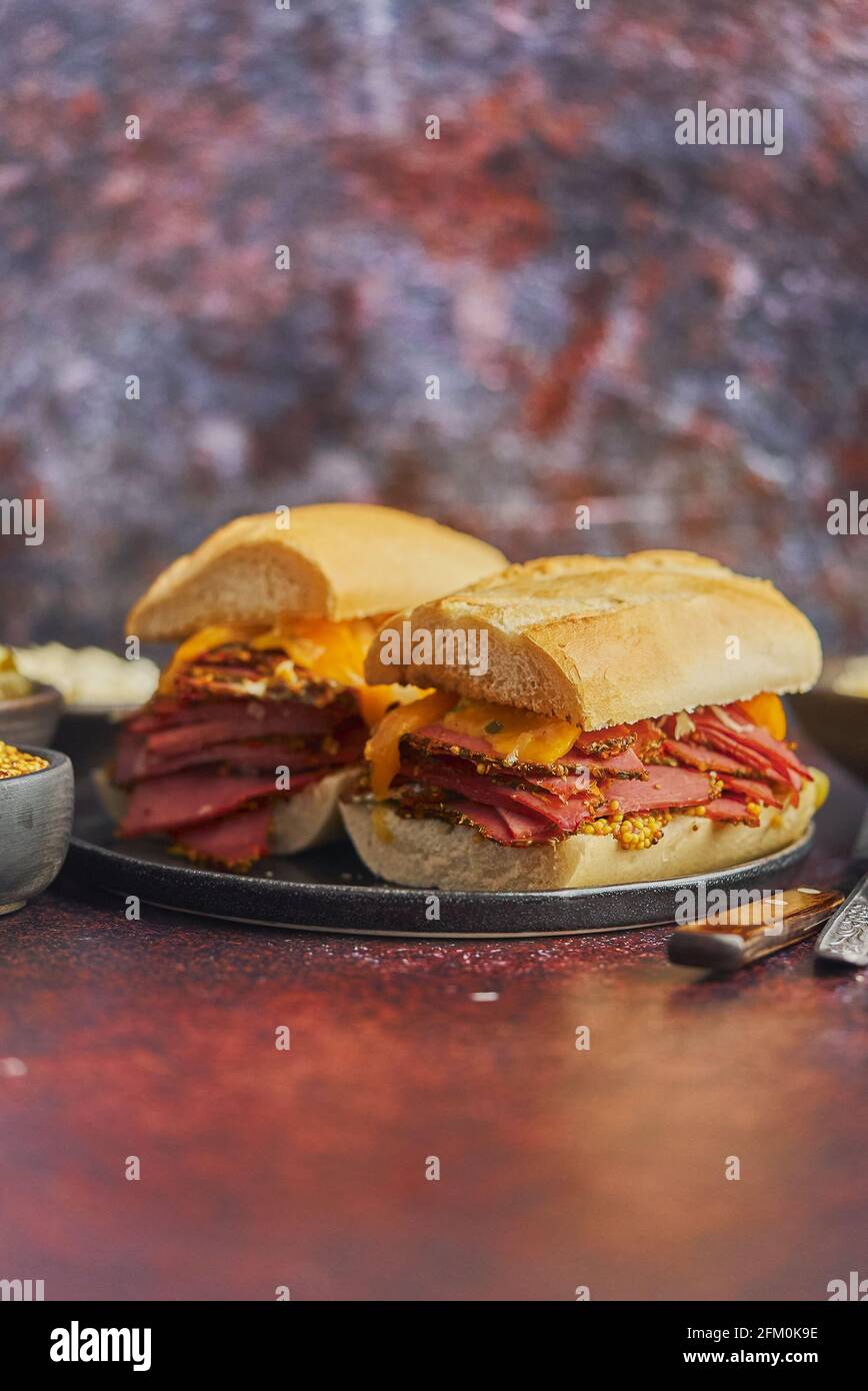 Sabrosos sándwiches de reuben a la parrilla de gran lujo con carne de pastrami y queso cheddar Foto de stock