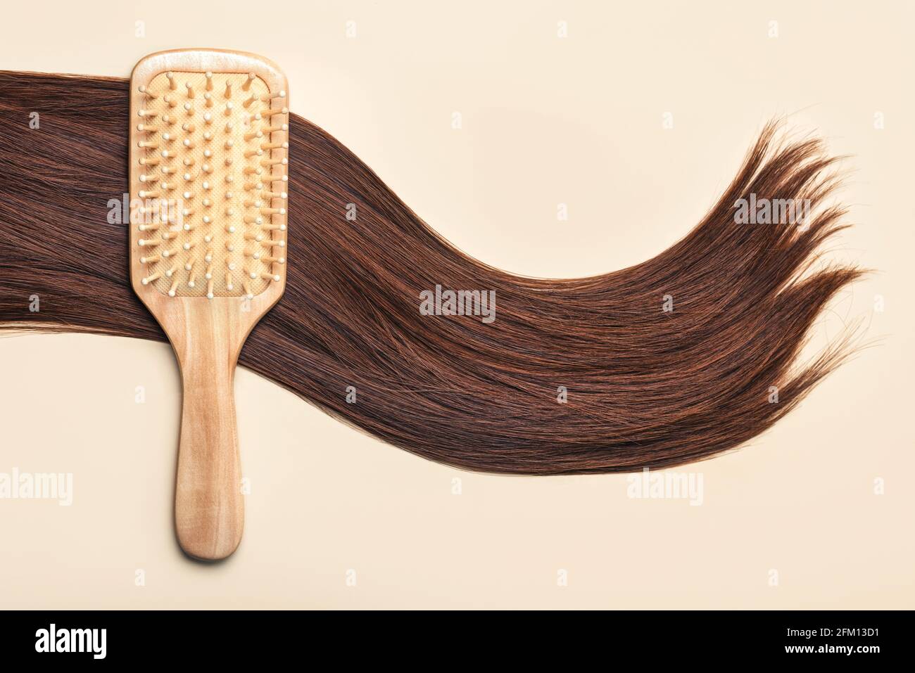 Cepillo de pelo con cierre de pelo marrón femenino sobre un beige Background.Peluquería salón y peinados concepto Foto de stock